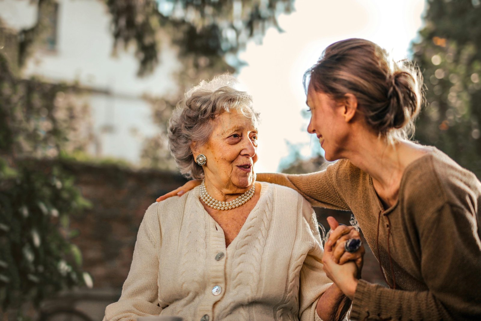Older woman, talking to a younger woman in a garden